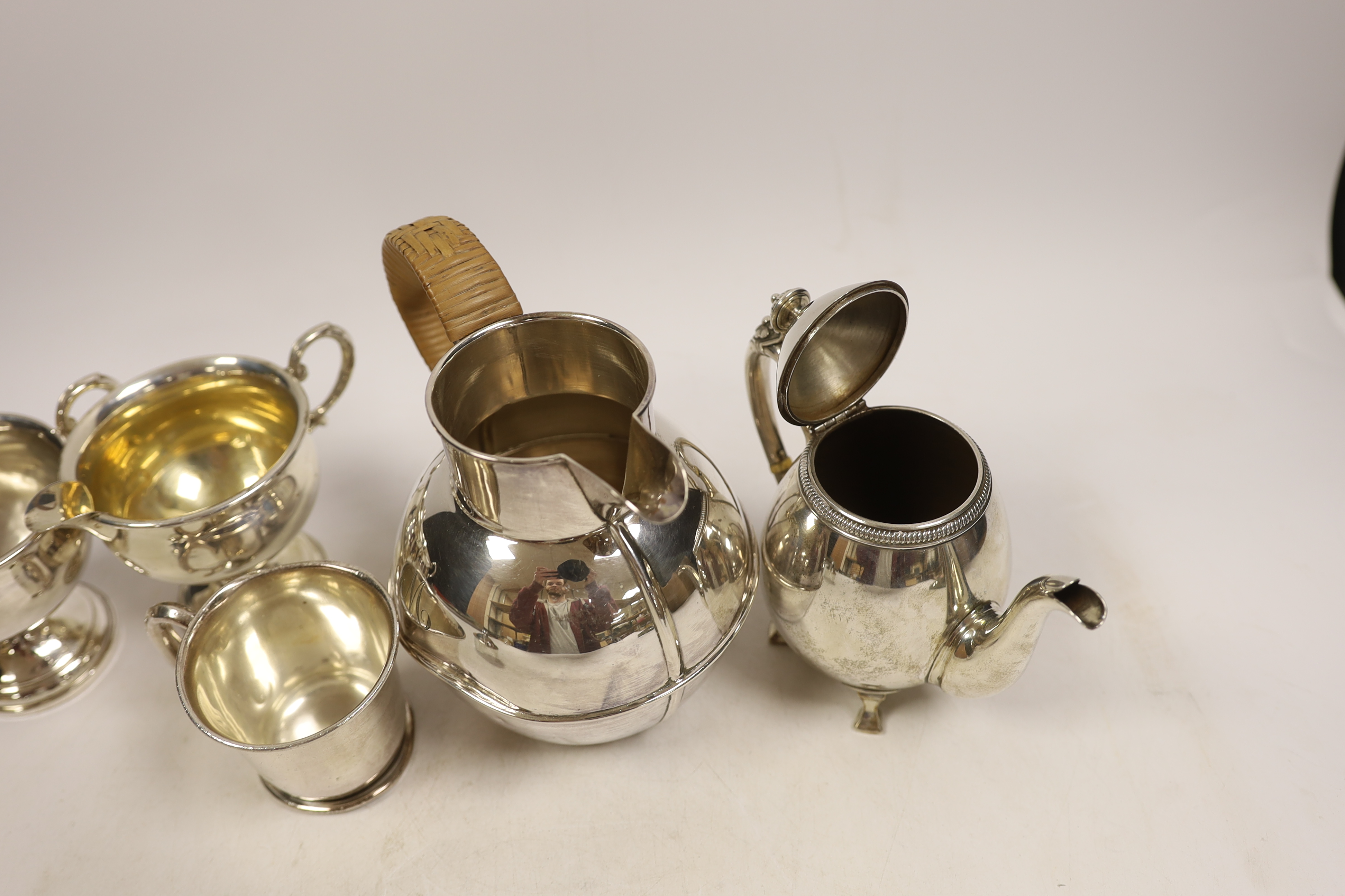 An Elizabeth II silver 'Guernsey' milk can, Kenneth Tyler Key, Birmingham, 1966, height 16.4cm, a sterling bachelor's teapot, sterling cream and sugar (weighted?) and a silver christening mug, gross weight 27.2oz. CITES